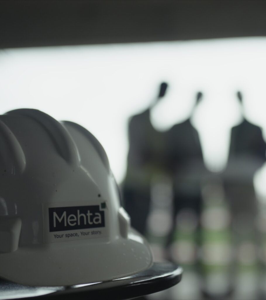 A detailed close-up of a Mehta Group safety helmet on a construction site, embodying the group's core values of safety, reliability, and superior quality standards in every residential and commercial development.