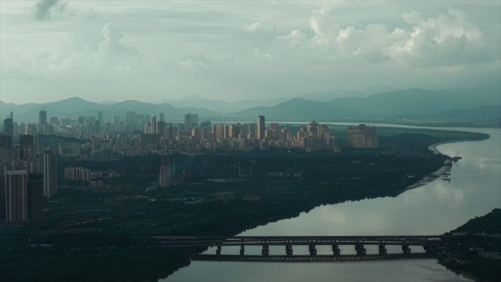 A breathtaking panoramic view of a modern urban skyline along a serene riverfront, illustrating the scale of metropolitan growth and the vast potential for luxury residential and commercial real estate development in a coastal city.
